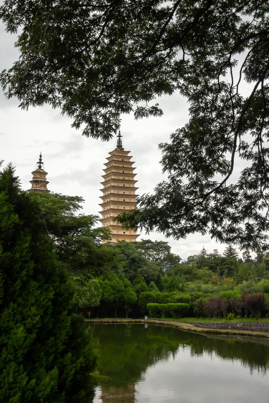 Three Pagodas framed by trees with Cangshan behind