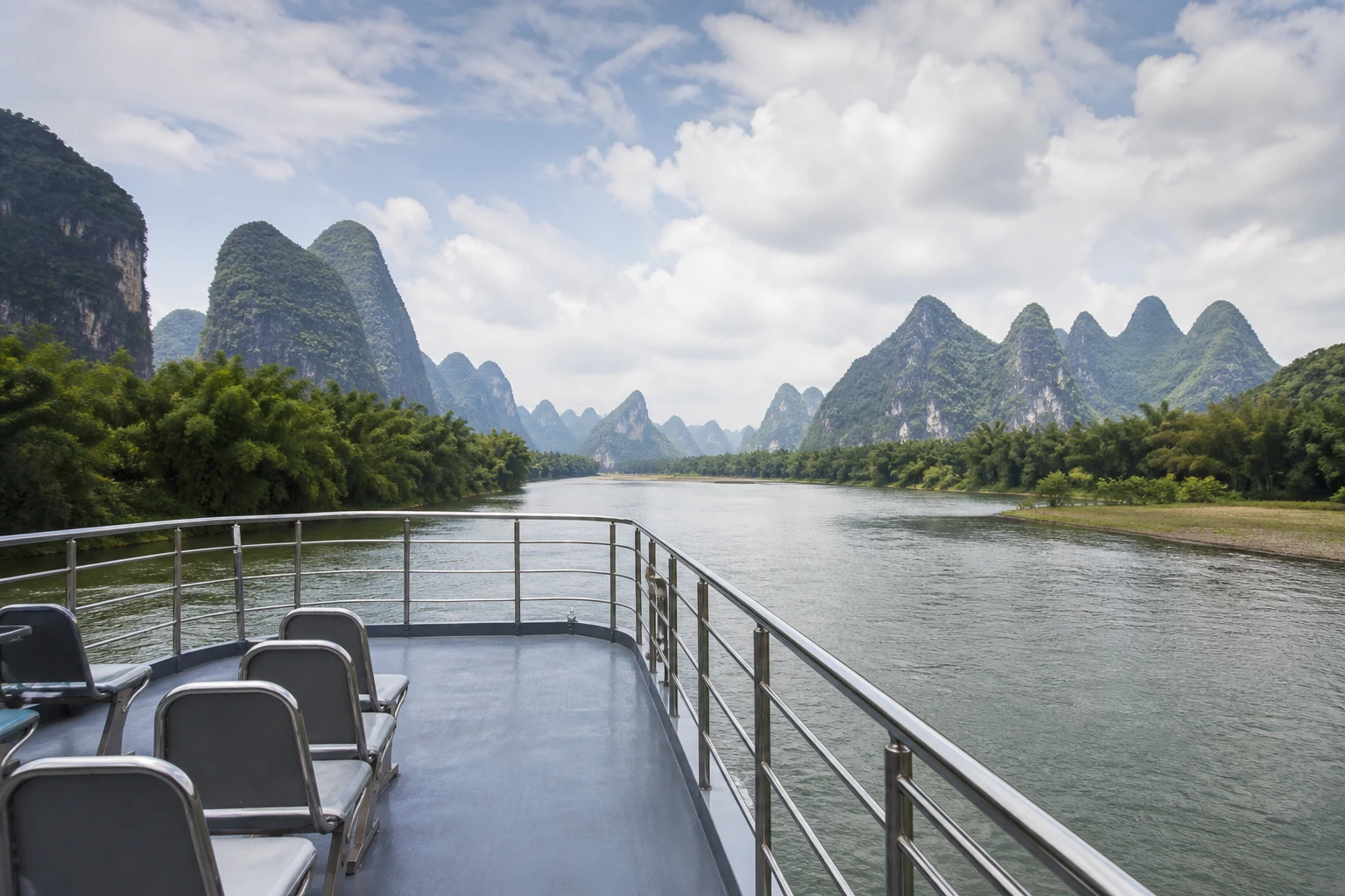 View from an unbranded Li River cruise deck toward karst peaks