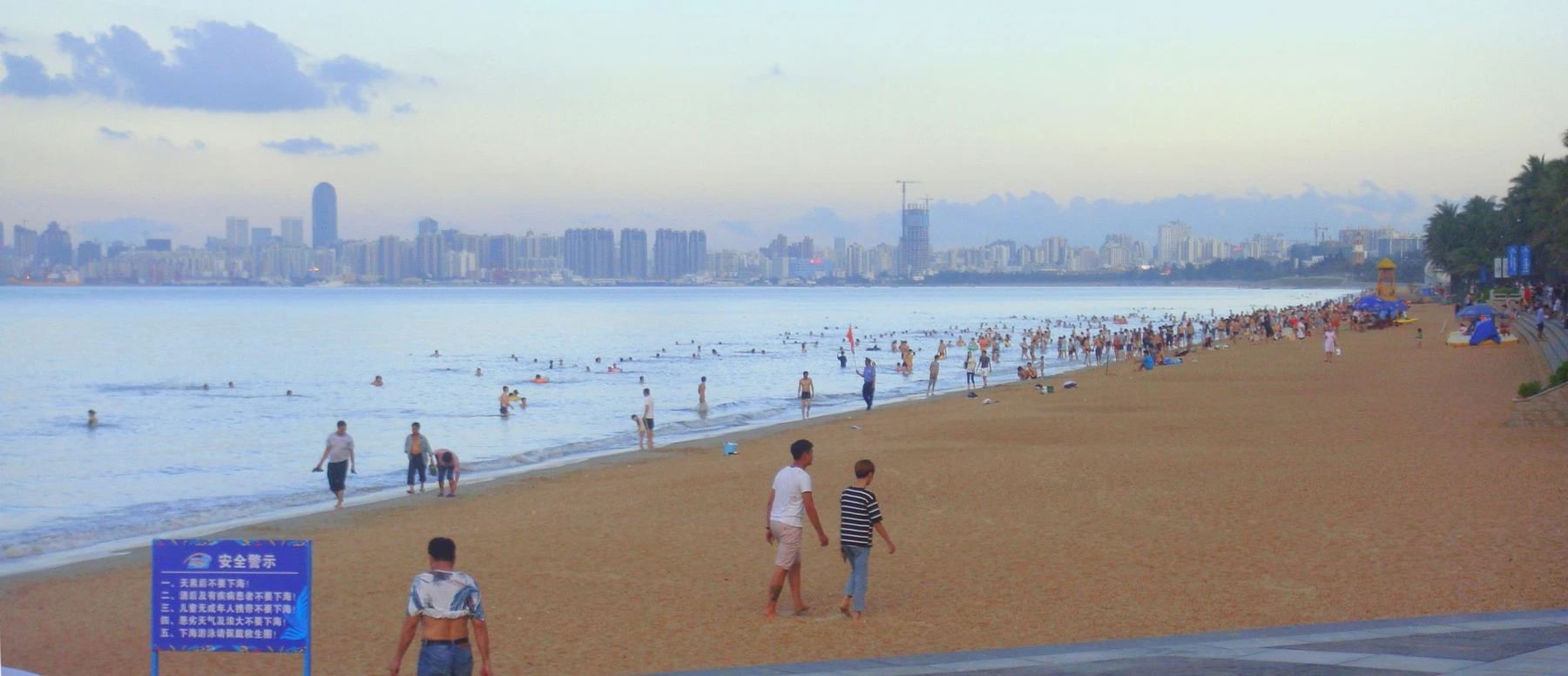 Visitors and broad shoreline at Holiday Beach in Haikou