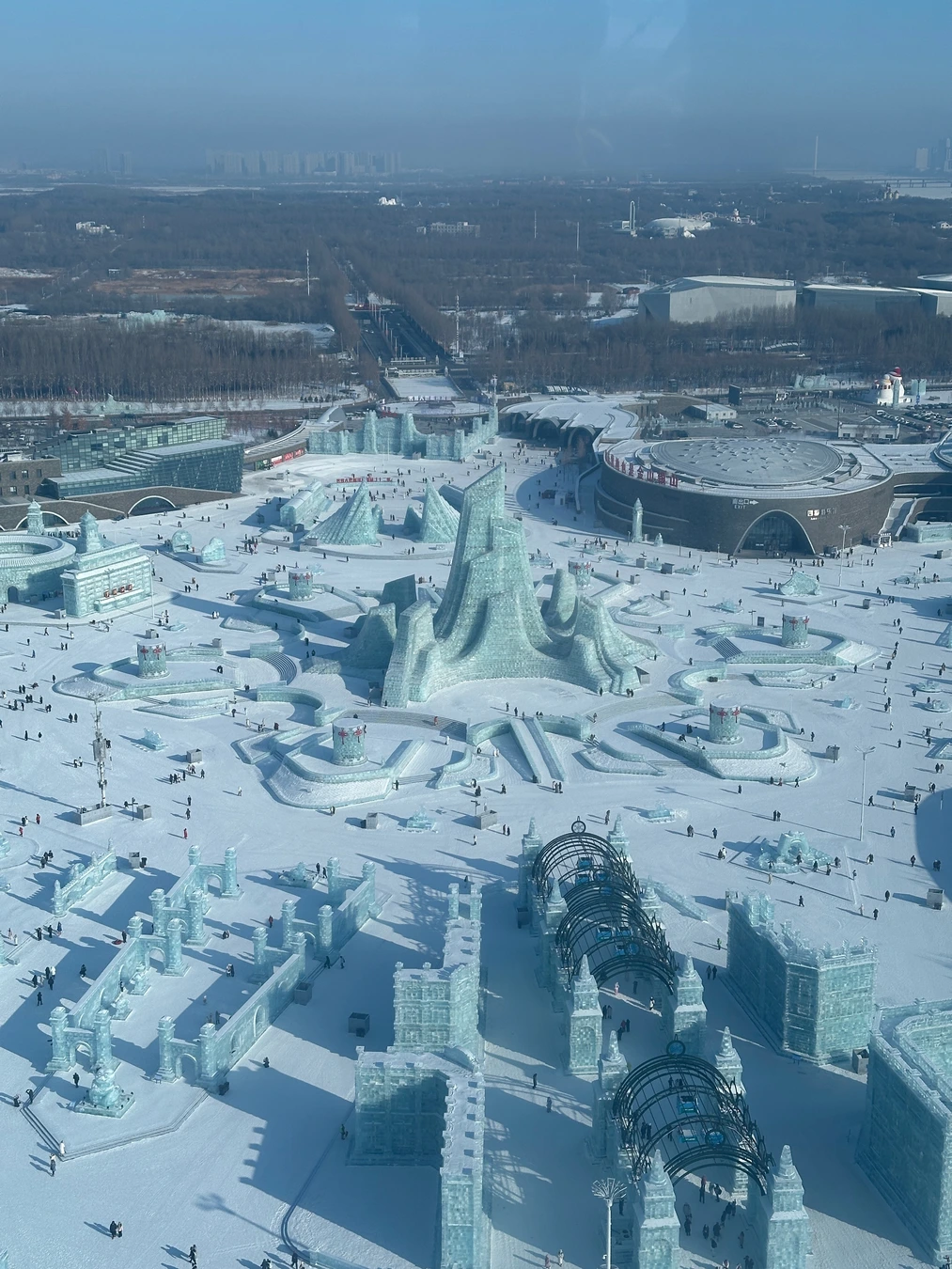 Daylight panorama of the seasonal Harbin ice park under construction and operation