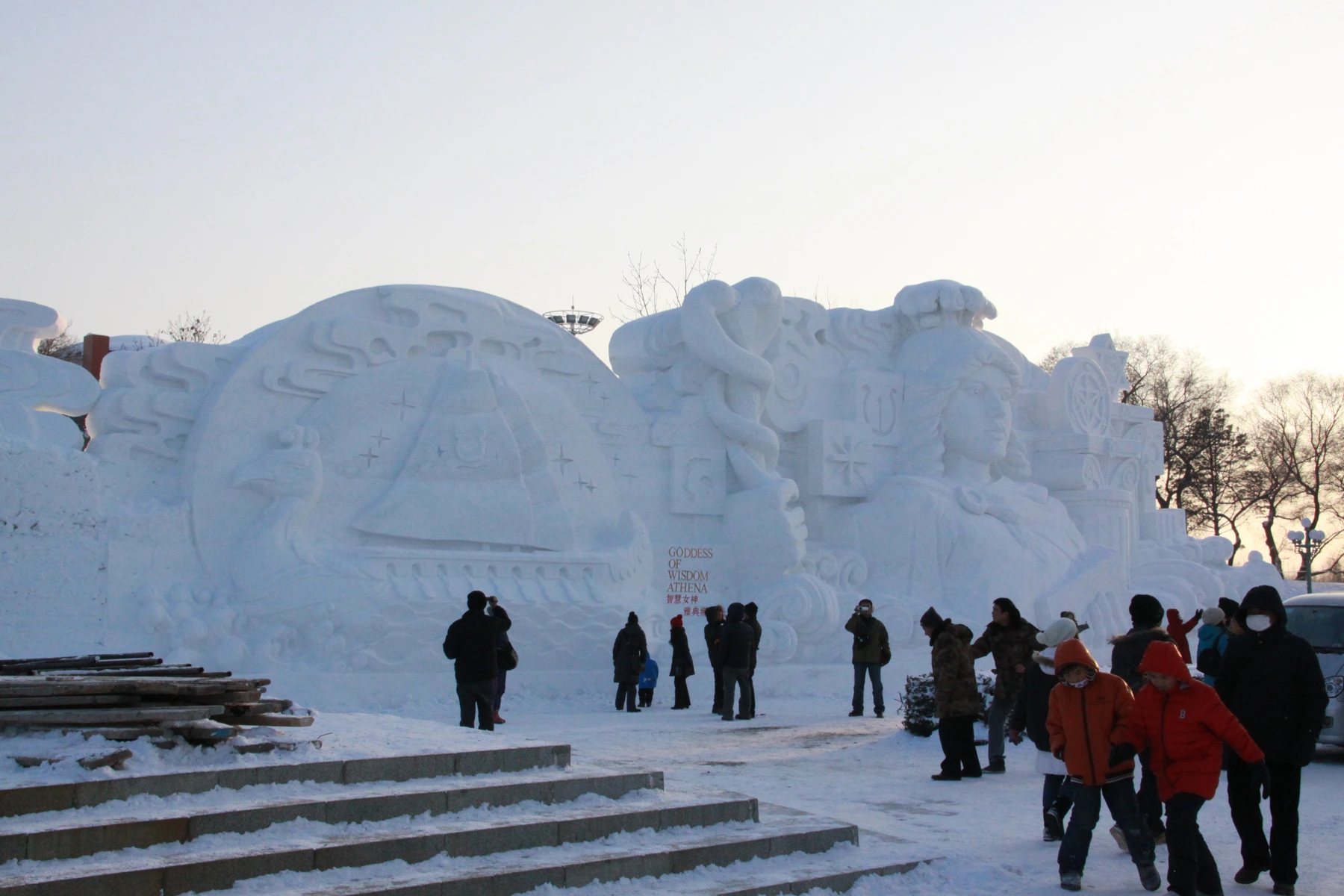 Visitors showing the scale of a large Sun Island snow sculpture