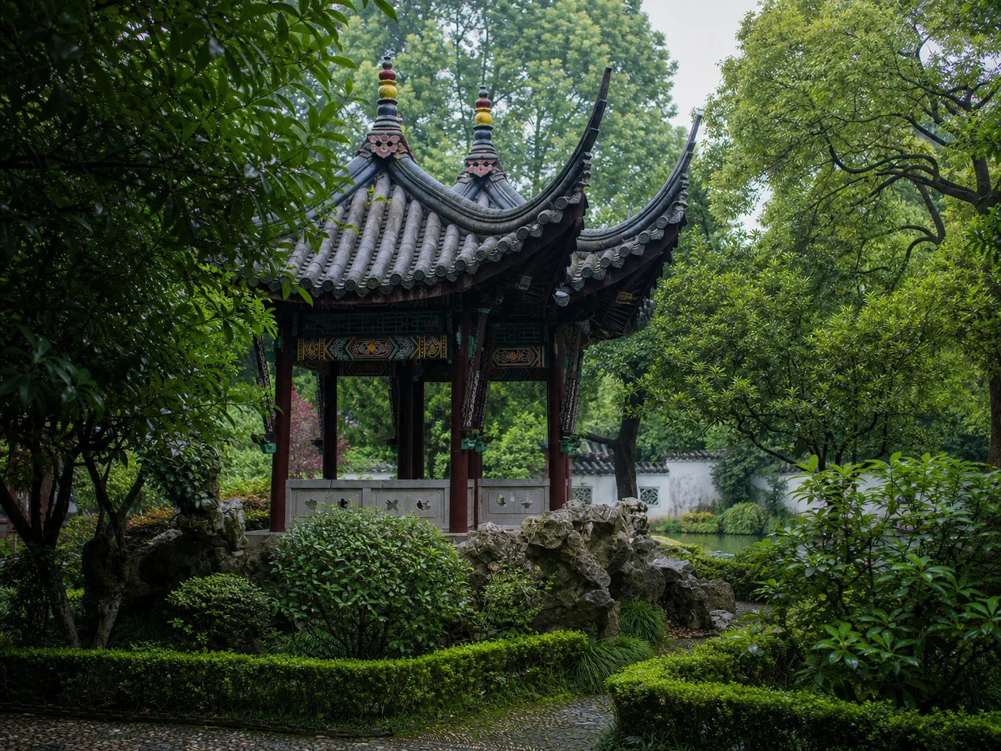AI-regenerated editorial view of a pavilion, rockery and greenery in Xu Garden