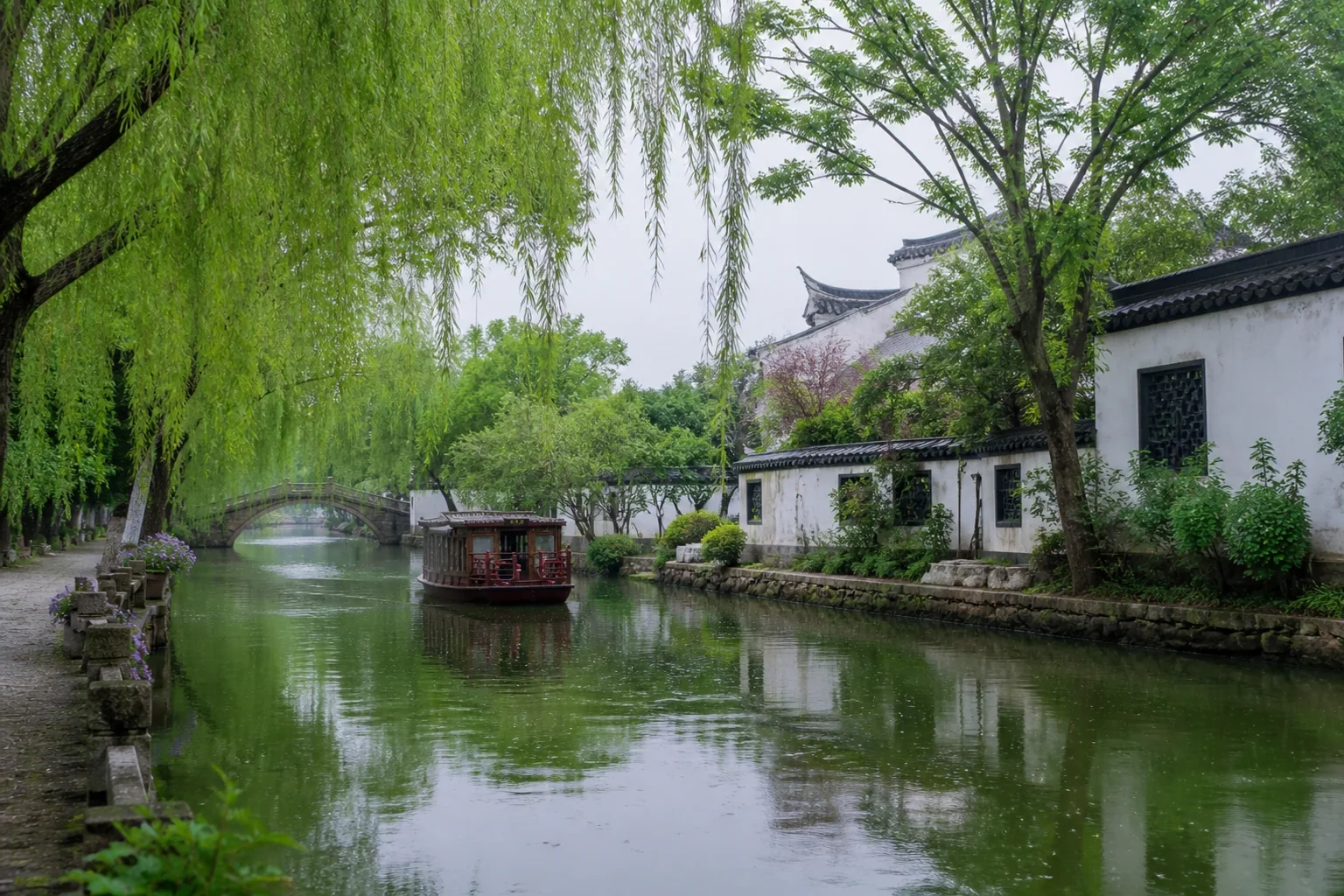 Daytime Qinhuai waterway with willow trees, white walls, a stone bridge and a covered boat