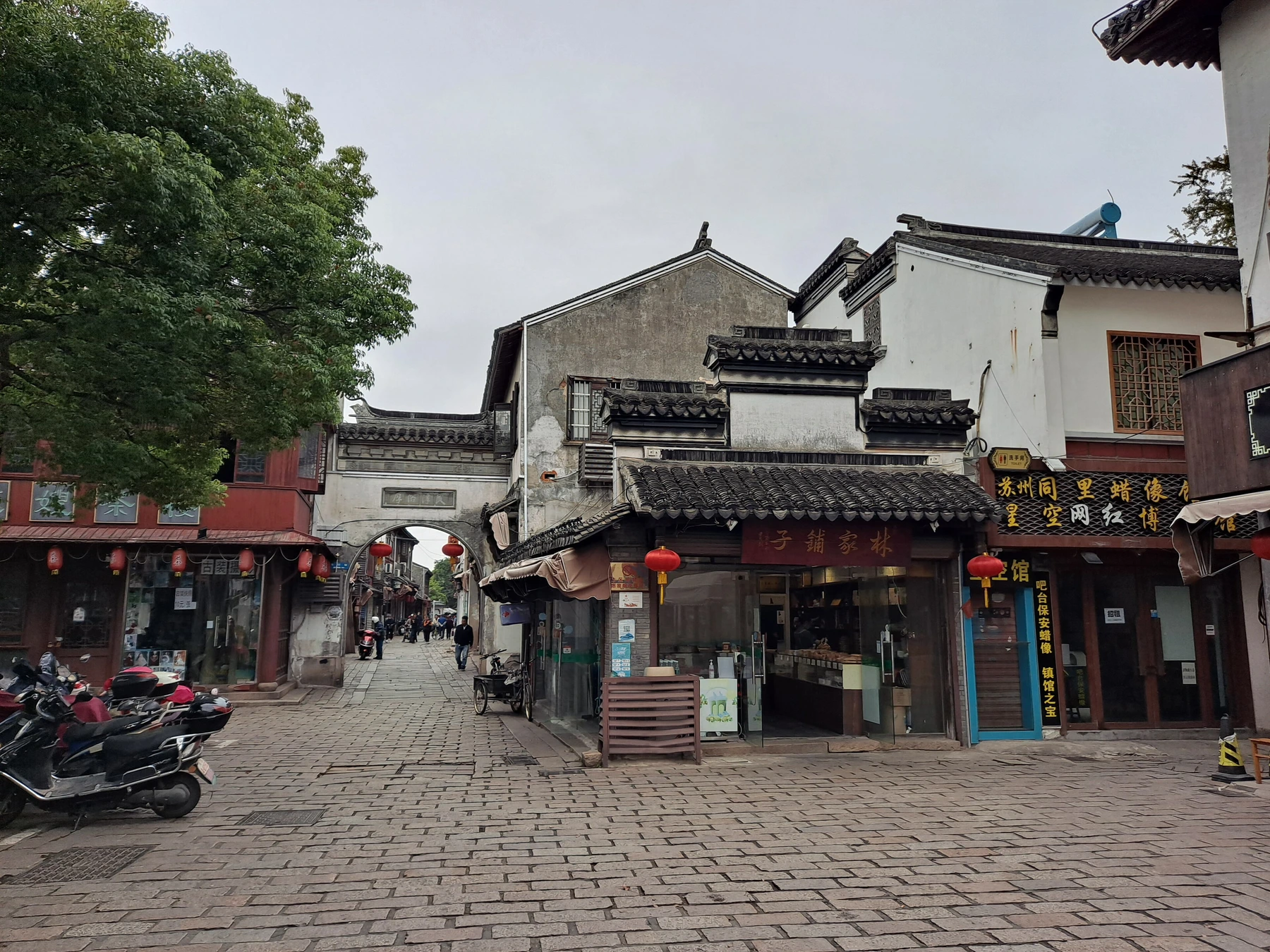Everyday lane, shops and white-walled houses inside Tongli