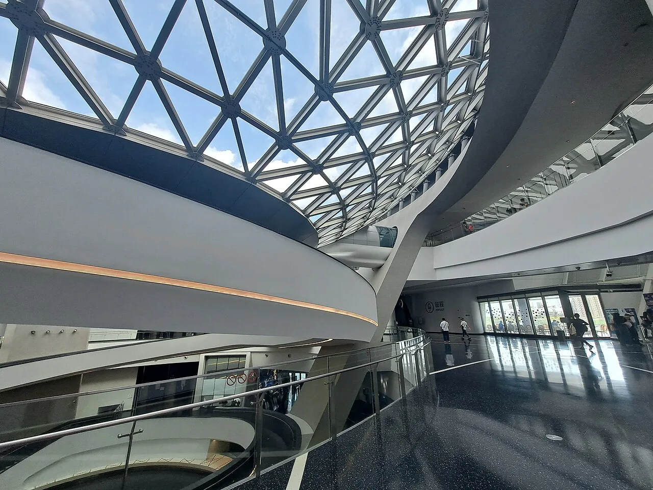 Curving interior galleries beneath the glass roof of Shanghai Astronomy Museum
