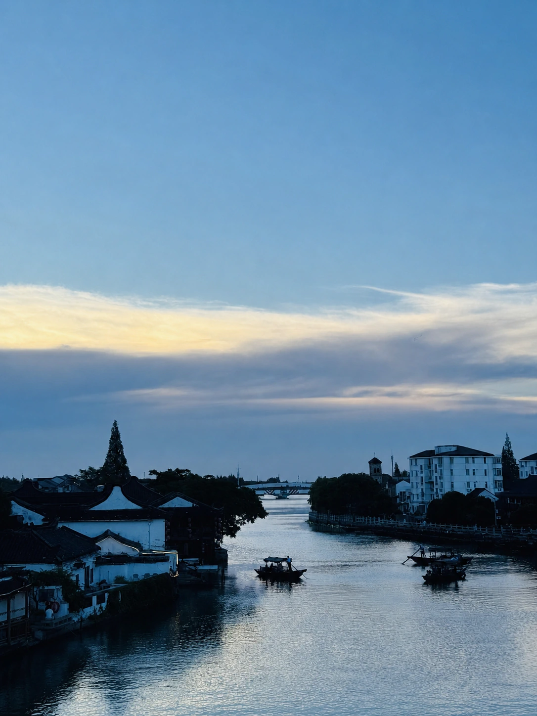 Boats and waterside houses along a canal in Zhujiajiao at dusk