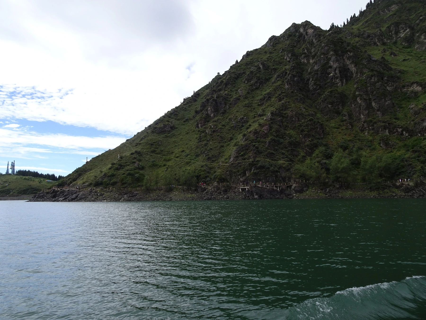 Boat on Heavenly Lake beneath the Tianshan mountain walls