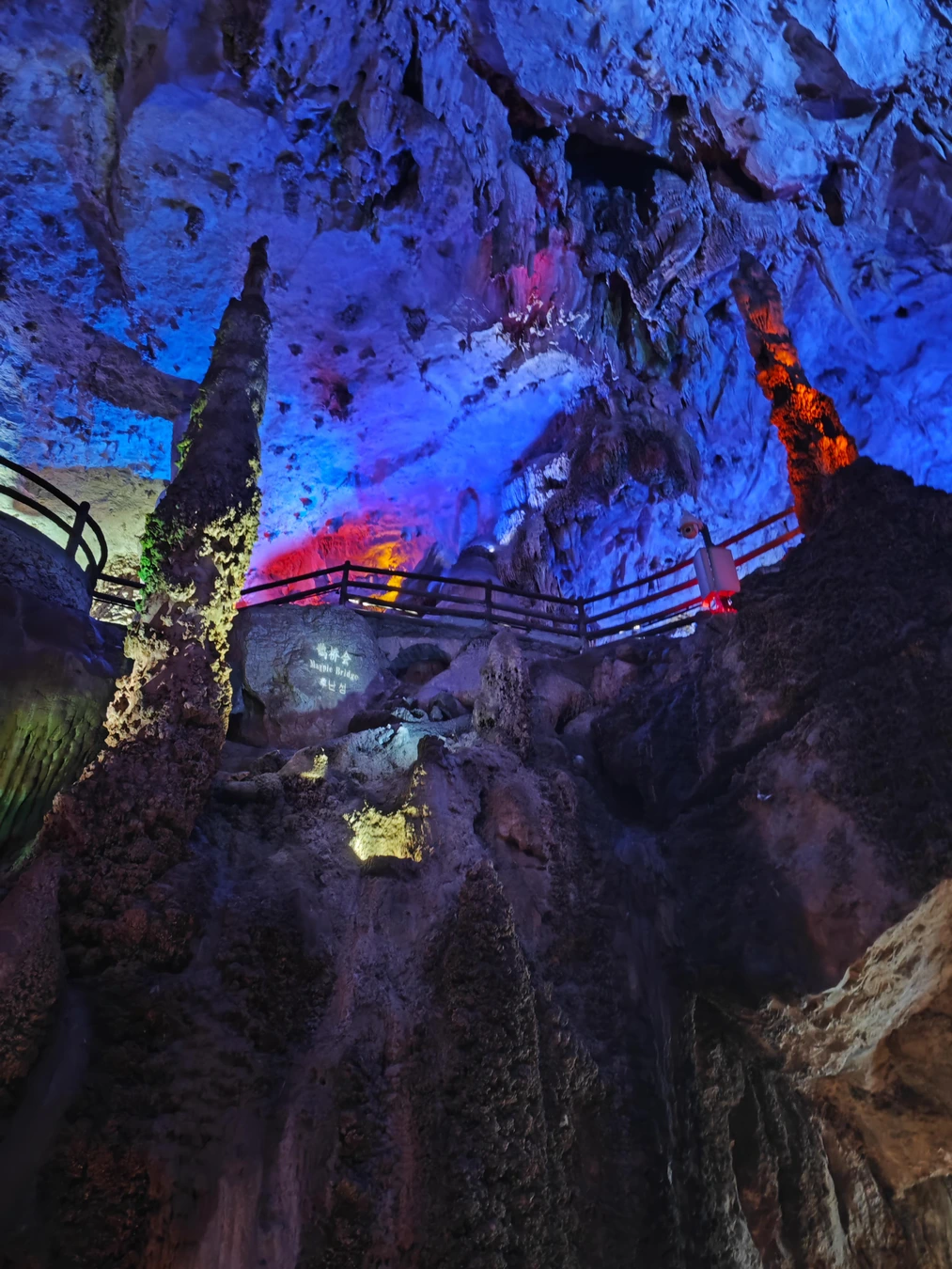 Color-lit cavern and rock formations inside Jiuxiang scenic area