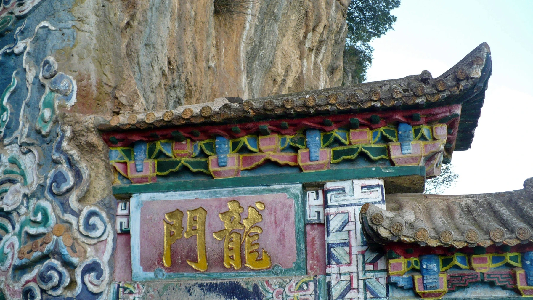 Painted Dragon Gate entrance set into the Western Hills cliff