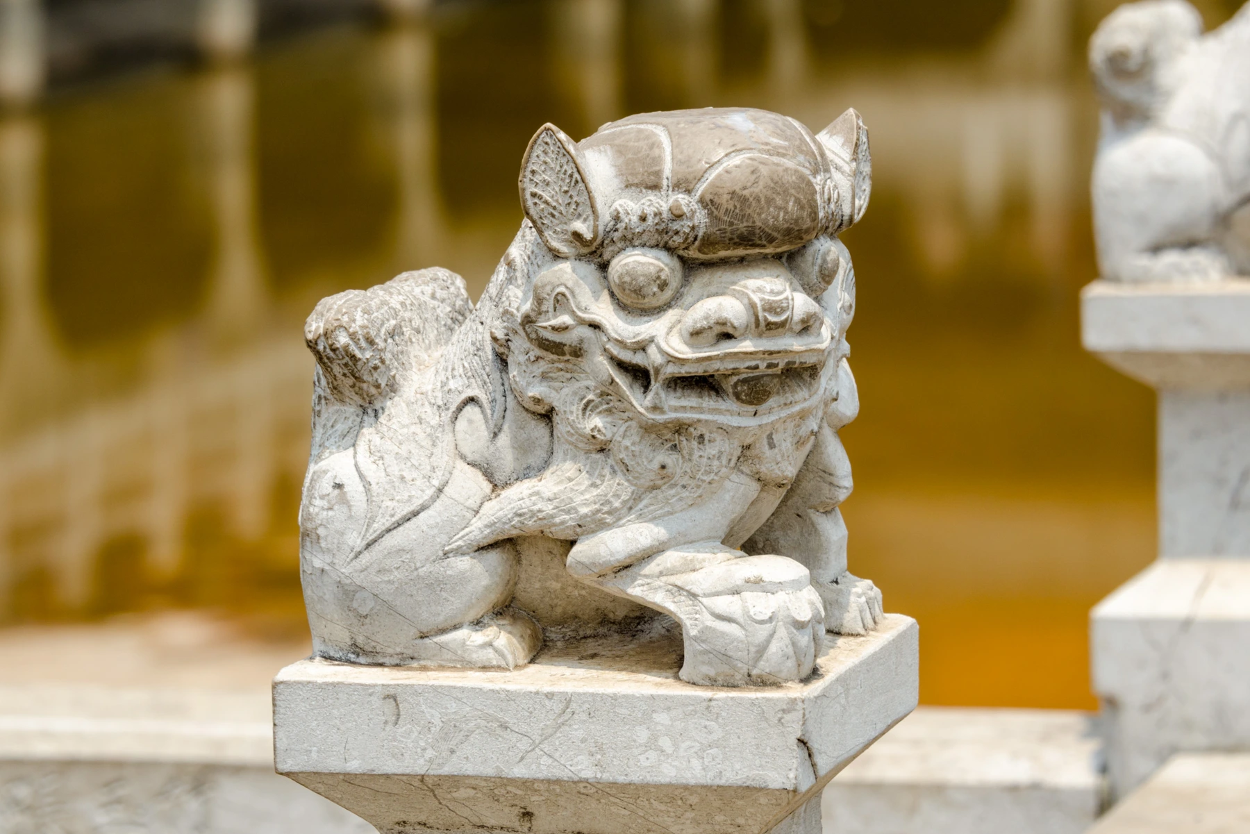 Stone guardian and reflective water at Yuantong Temple