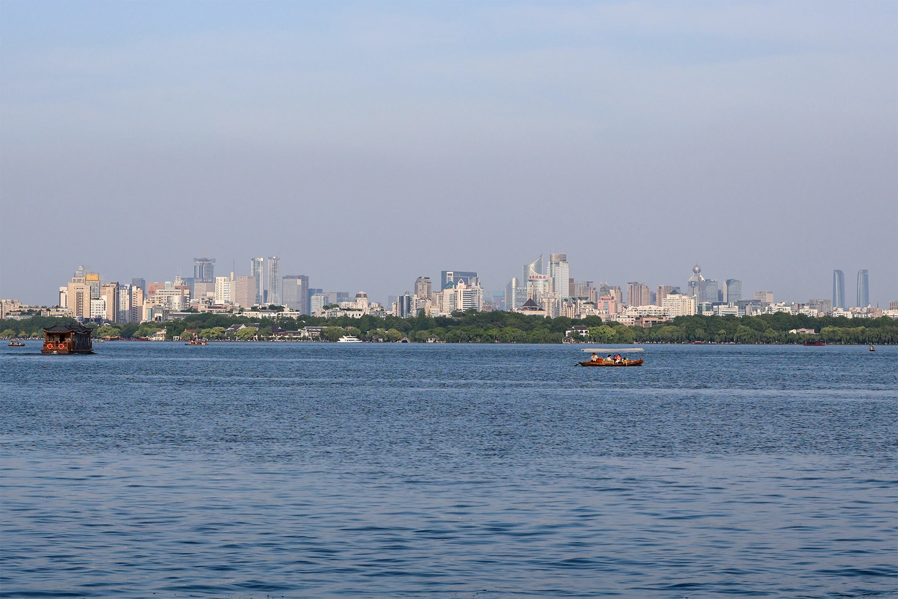 West Lake with boats and the Hangzhou skyline across the water