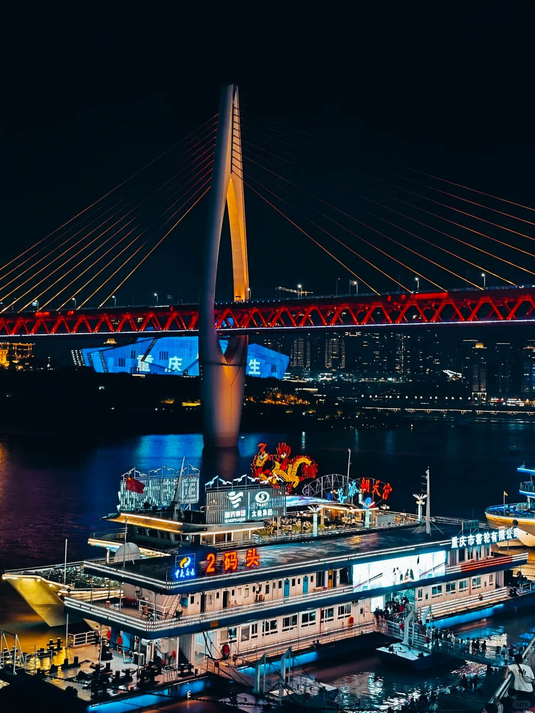 Night view of Hongya Cave with cruise boats and Qiansimen Bridge